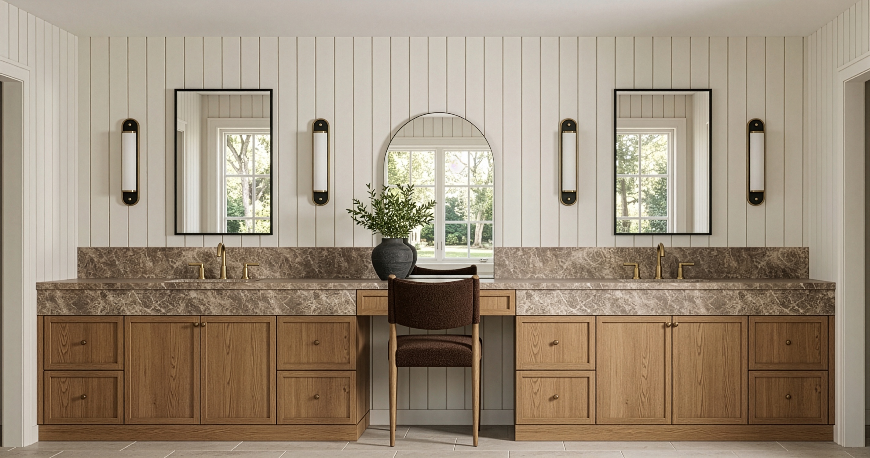 Primary bathroom vanity with arched mirror and brass fixtures designed by Chelsey Rain Interiors
